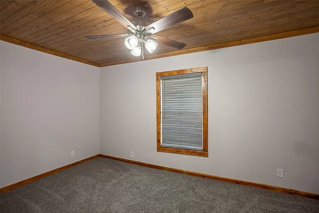 an empty room with a ceiling fan and window