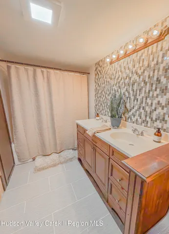 a spacious bathroom with a granite countertop sink and a mirror