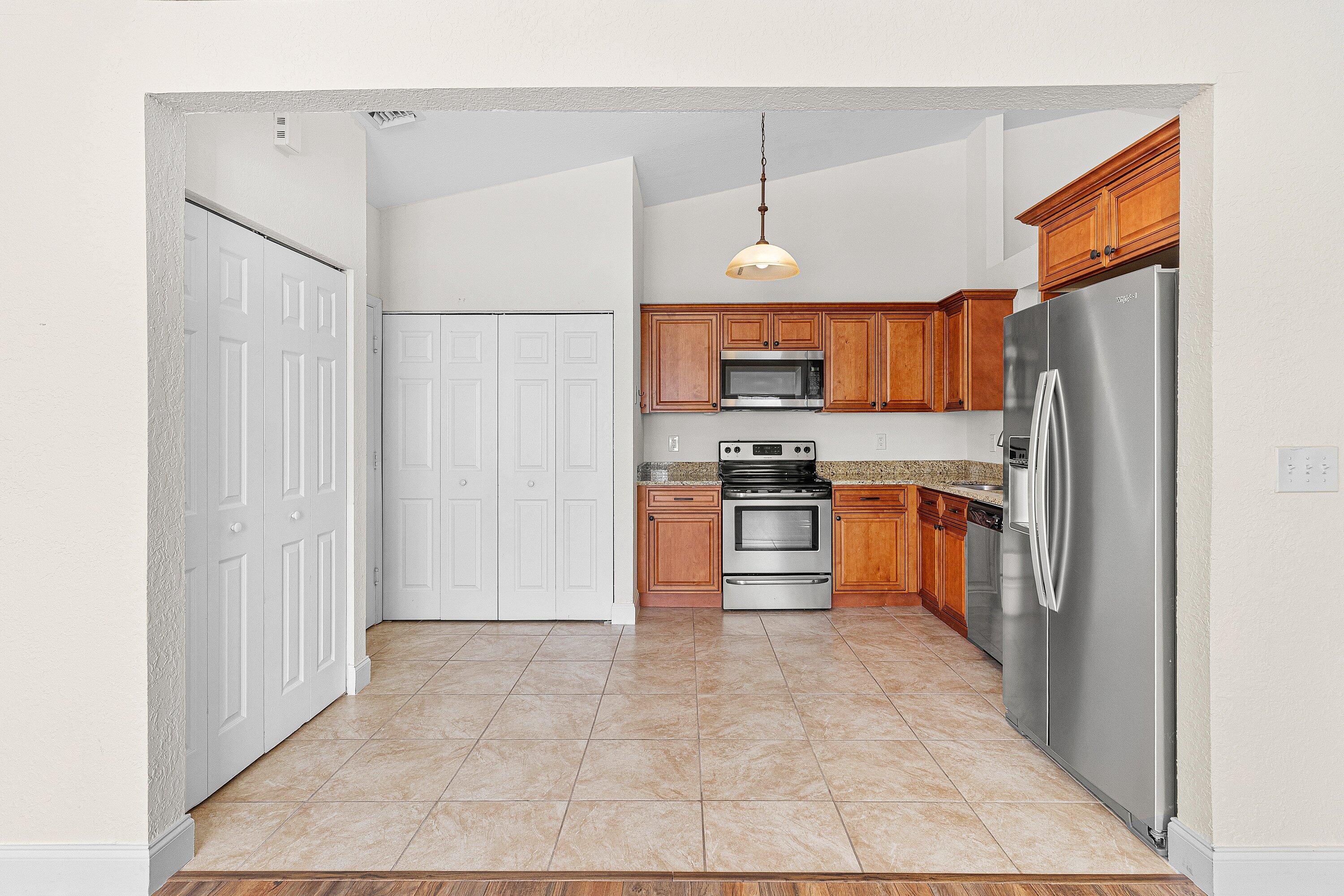 6081 Heliconia Road Delray Beach, FL 33484 - Photo 10 of 39 a kitchen with stainless steel appliances a refrigerator and a stove top oven