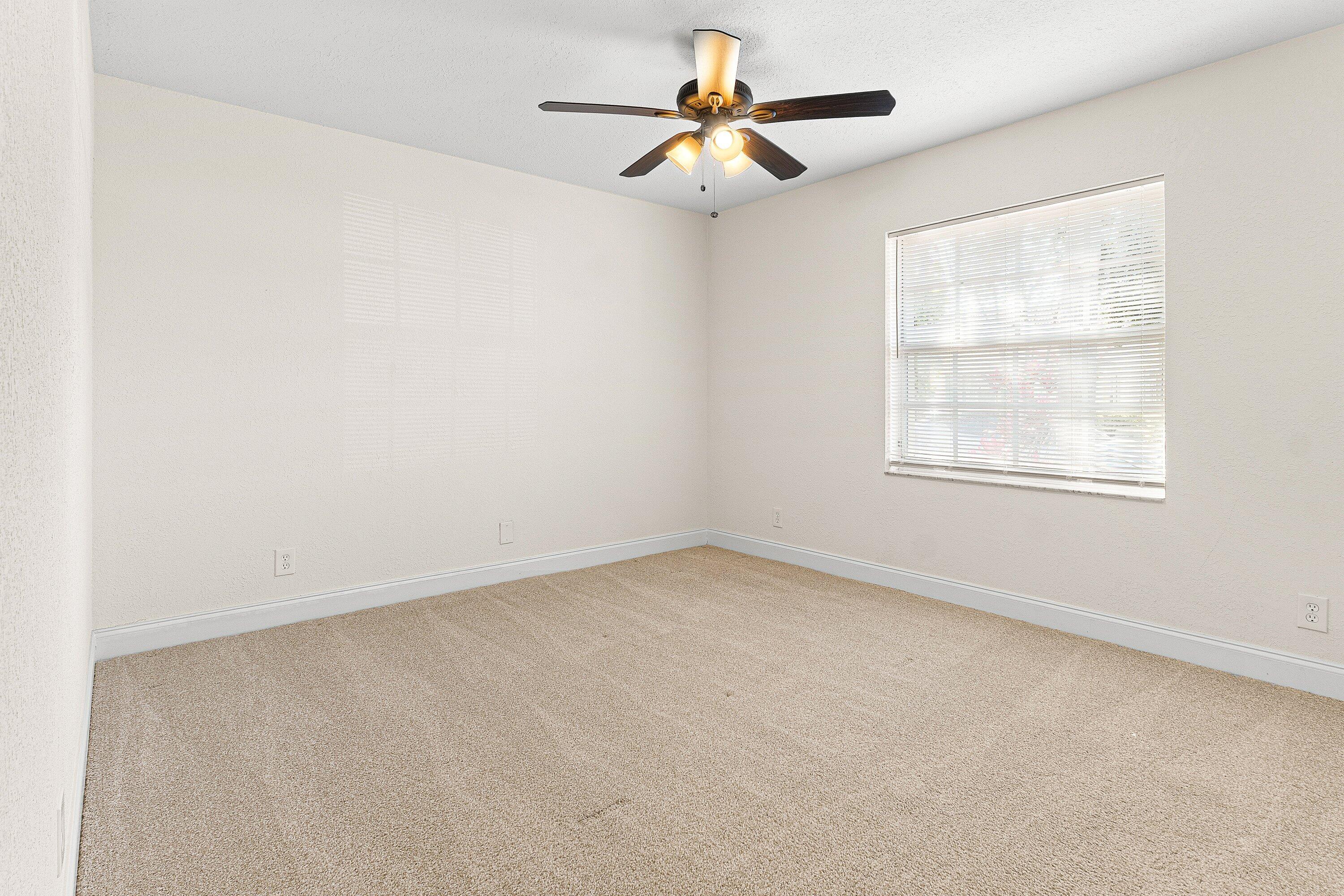 6081 Heliconia Road Delray Beach, FL 33484 - Photo 14 of 39 an empty room with a window and a fan