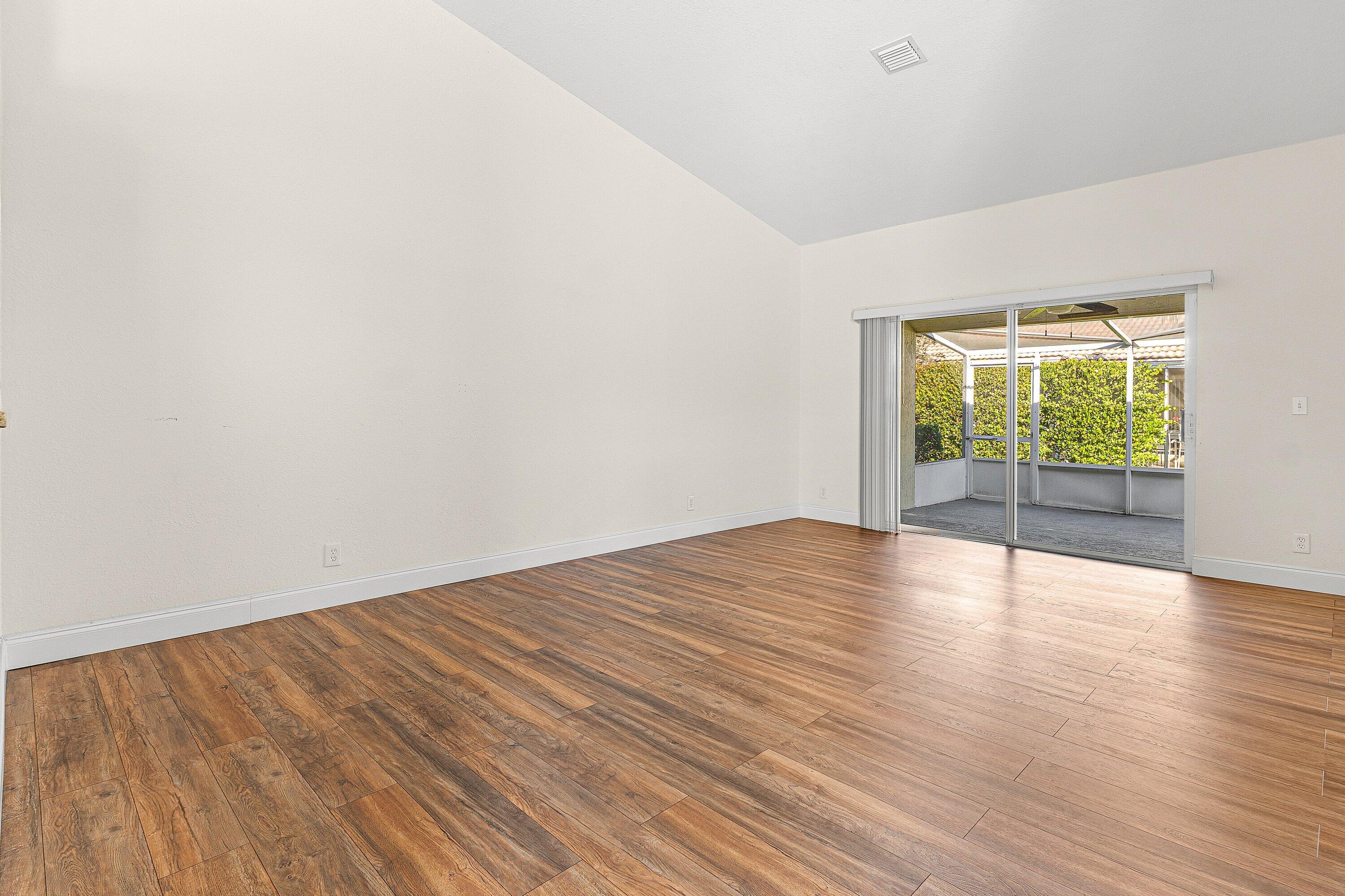 6081 Heliconia Road Delray Beach, FL 33484 - Photo 15 of 39 a view of an empty room with wooden floor and a window