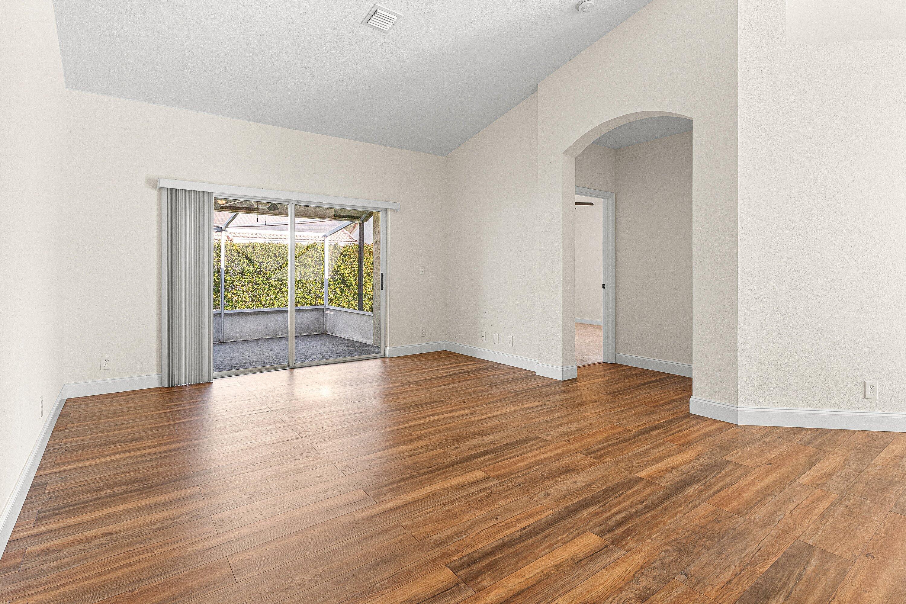 6081 Heliconia Road Delray Beach, FL 33484 - Photo 16 of 39 an empty room with wooden floor and windows