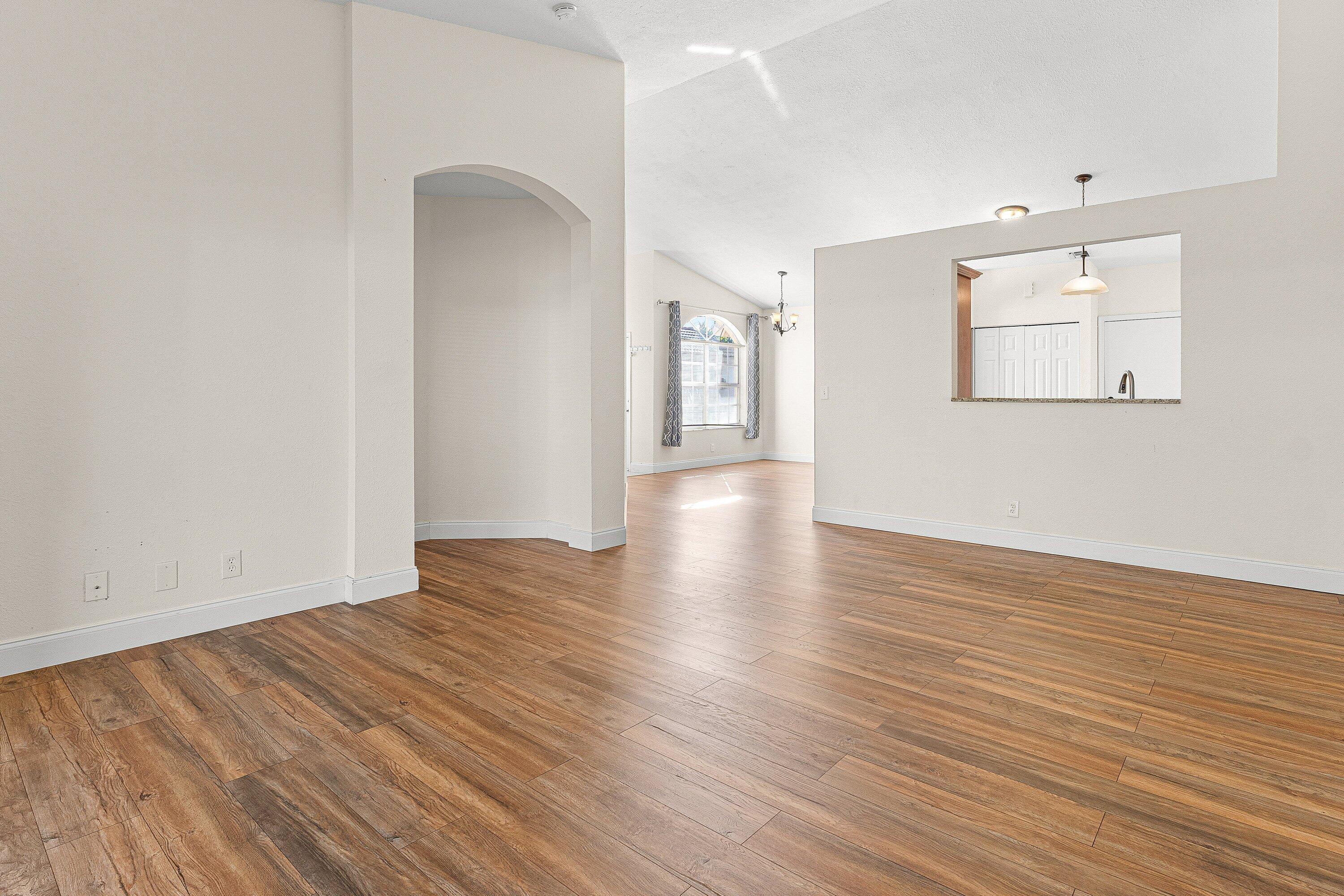 6081 Heliconia Road Delray Beach, FL 33484 - Photo 18 of 39 a view of an empty room with wooden floor and a window