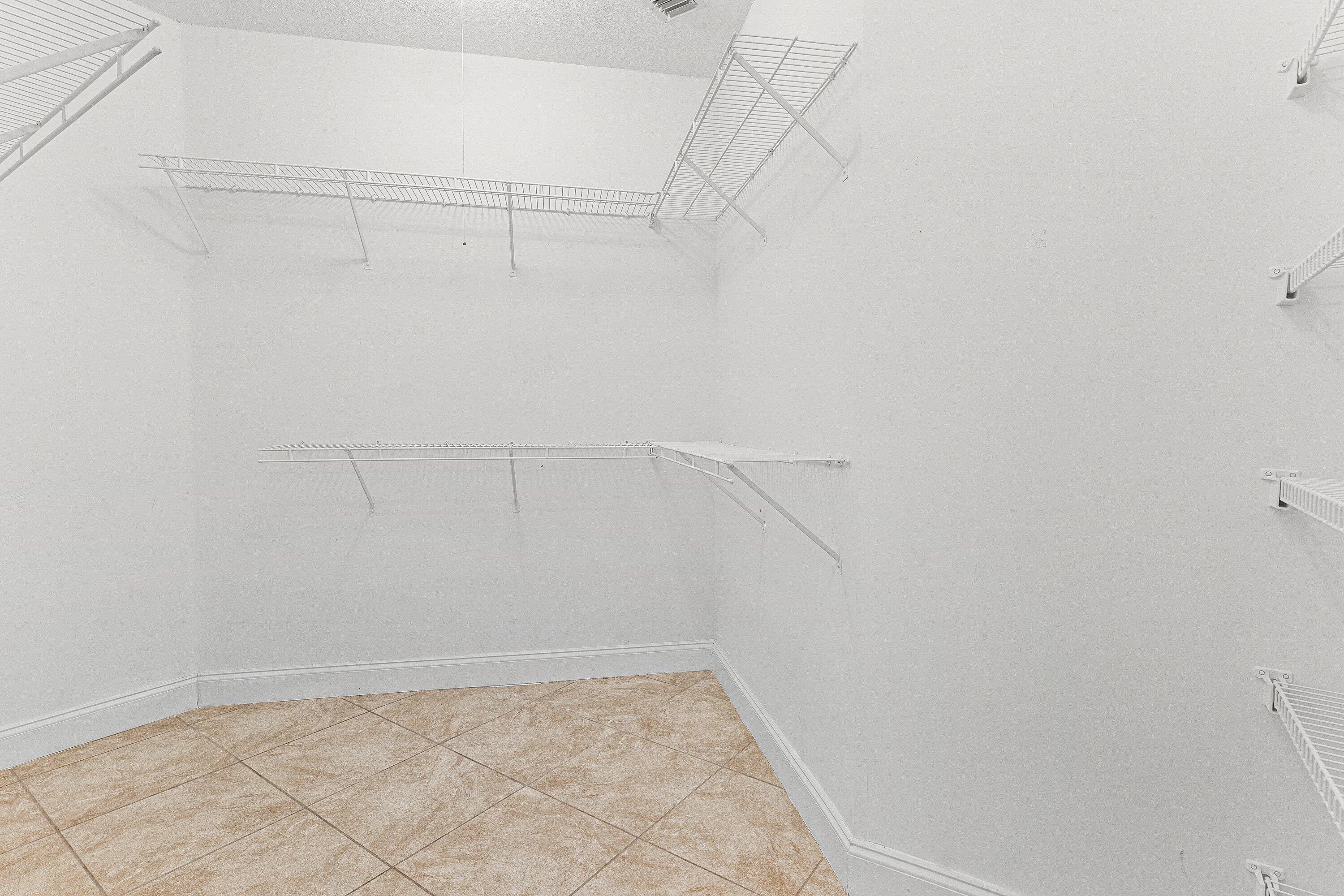 6081 Heliconia Road Delray Beach, FL 33484 - Photo 22 of 39 a view of a room with racks on the wall