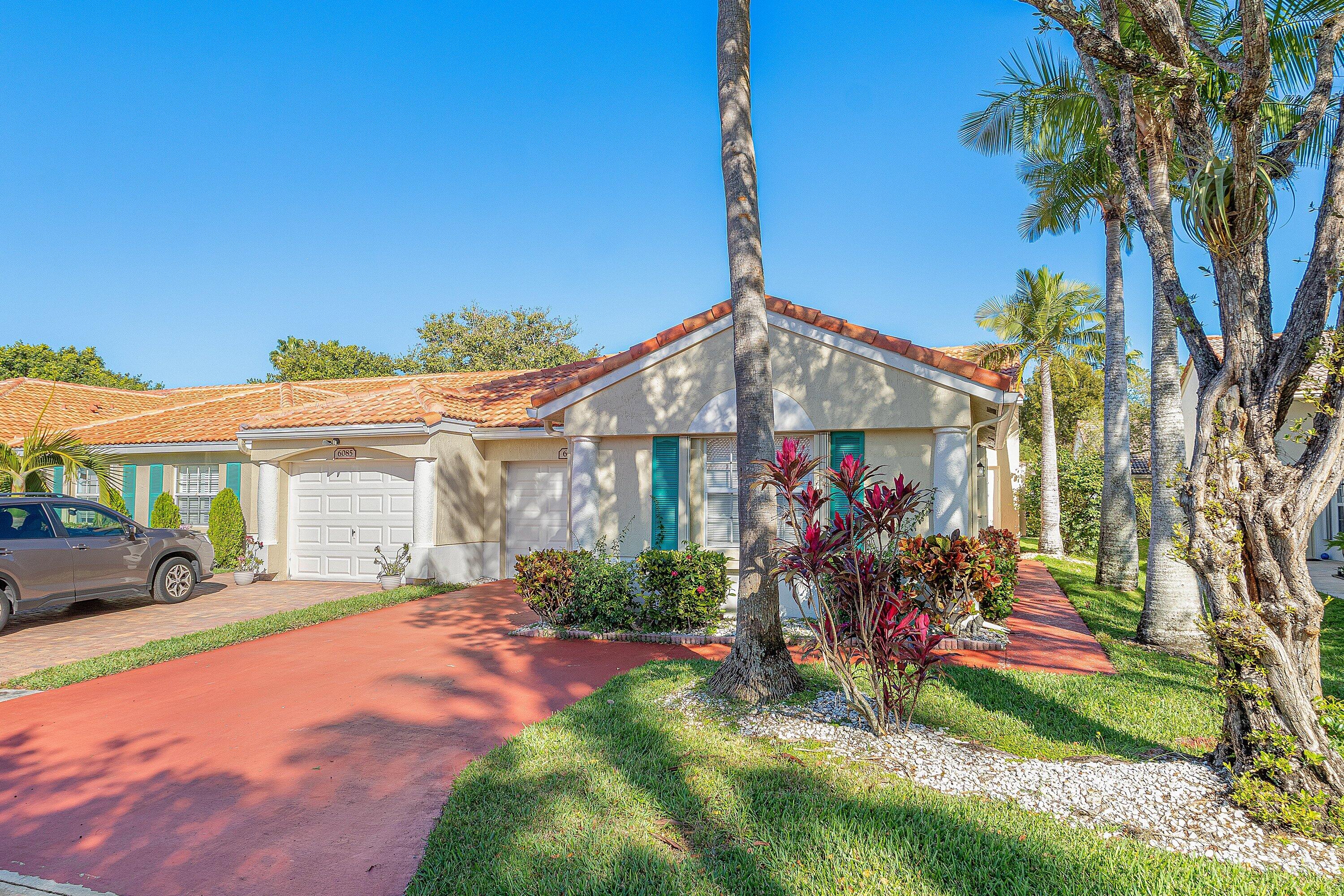 6081 Heliconia Road Delray Beach, FL 33484 - Photo 3 of 39 a front view of a house with garden