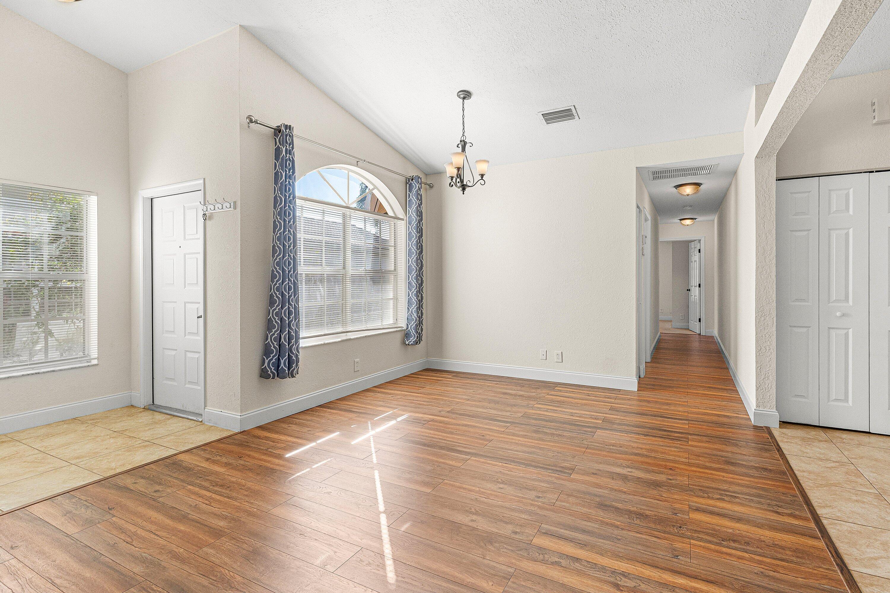 6081 Heliconia Road Delray Beach, FL 33484 - Photo 6 of 39 a view of an empty room with wooden floor and a window