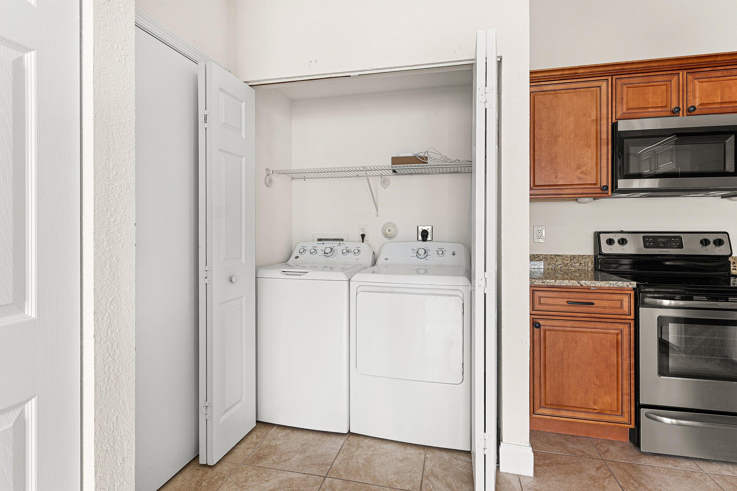 6081 Heliconia Road Delray Beach, FL 33484 - Photo 7 of 39 a utility room with cabinets washer and dryer