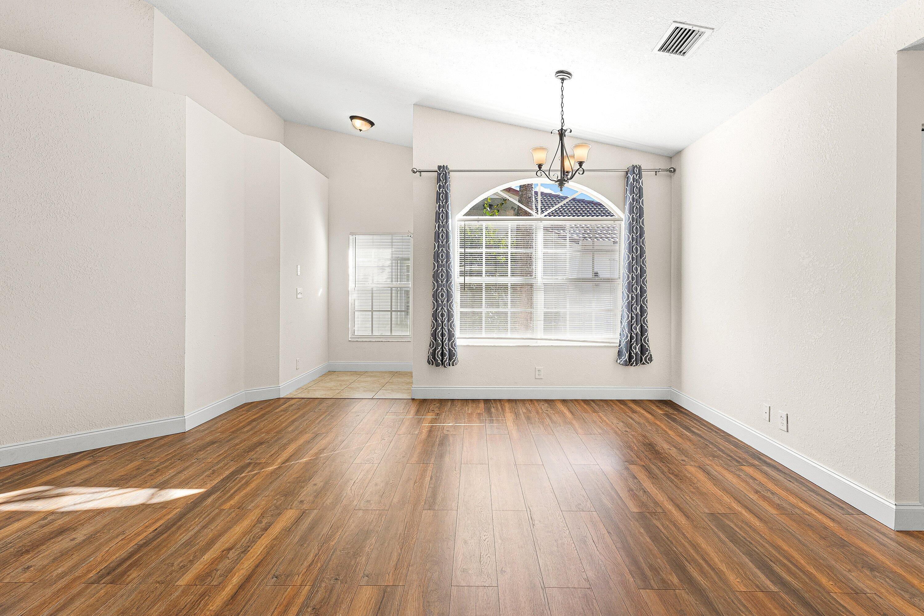 6081 Heliconia Road Delray Beach, FL 33484 - Photo 39 of 39 a view of an empty room with wooden floor and a window
