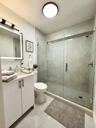 a white toilet sitting next to a bathroom sink