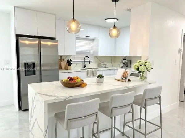 a kitchen with stainless steel appliances granite countertop a sink a refrigerator and a stove