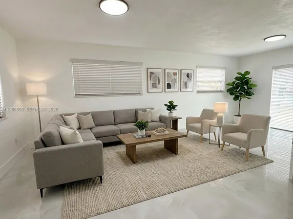 a living room with furniture and a potted plant