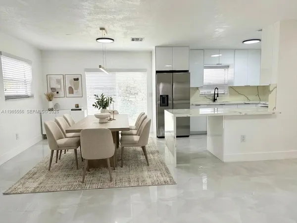 a view of kitchen with refrigerator dining table and chairs