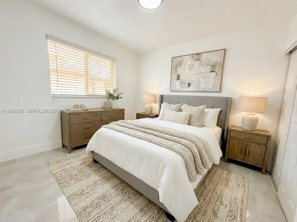 a bedroom with a bed and a painting on the wall