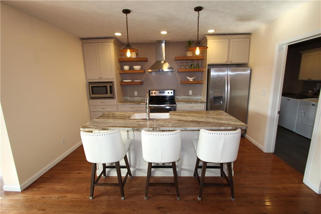 169 Wilpen Road Ligonier, PA 15658 - Photo 19 of 49 a kitchen with stainless steel appliances granite countertop a kitchen island hardwood floor and a sink