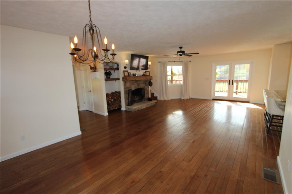 169 Wilpen Road Ligonier, PA 15658 - Photo 22 of 49 an empty room with wooden floor chandelier and windows
