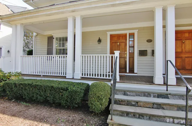a view of a house with a small yard and wooden floor and fence