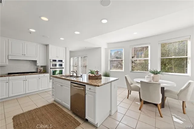 a kitchen with a sink and chairs