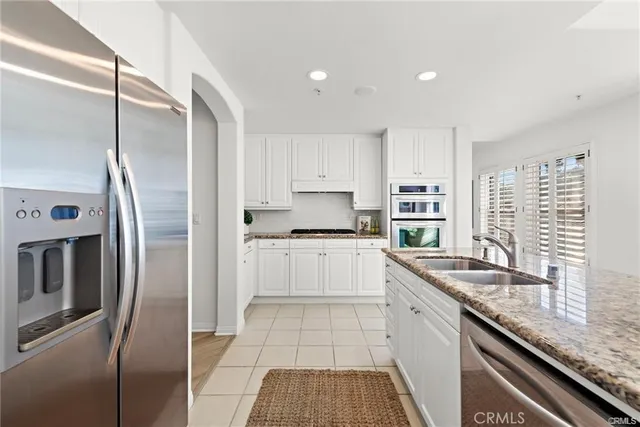 a kitchen with a refrigerator sink and cabinets