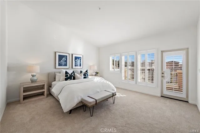 a spacious bedroom with a bed a table and large window