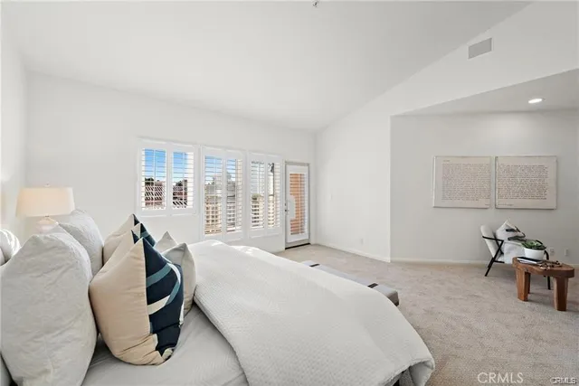 a spacious bedroom with a bed and wooden floor