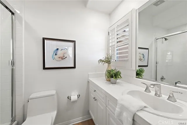 a bathroom with a granite countertop sink mirror and toilet