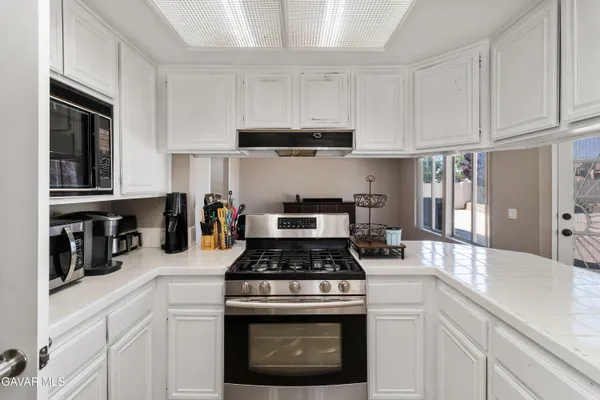 a kitchen with granite countertop white cabinets and stainless steel appliances