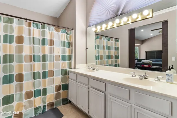 a bathroom with a double sink shower and a mirror