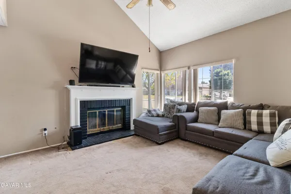 a living room with furniture a flat screen tv and a fireplace