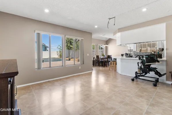 a view of a kitchen with kitchen island stainless steel appliances wooden floor dining table and chairs