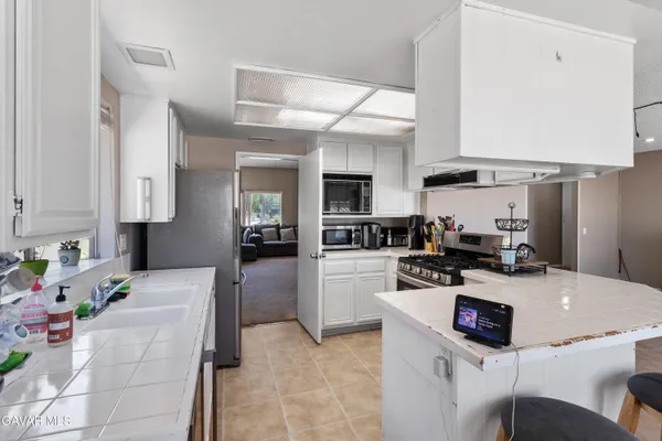a kitchen with a sink a stove and chairs