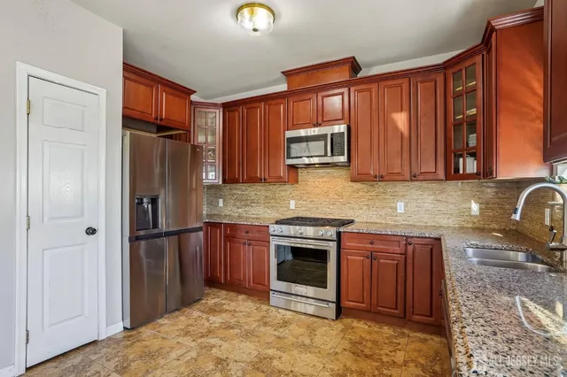 a kitchen with stainless steel appliances granite countertop a refrigerator and a sink