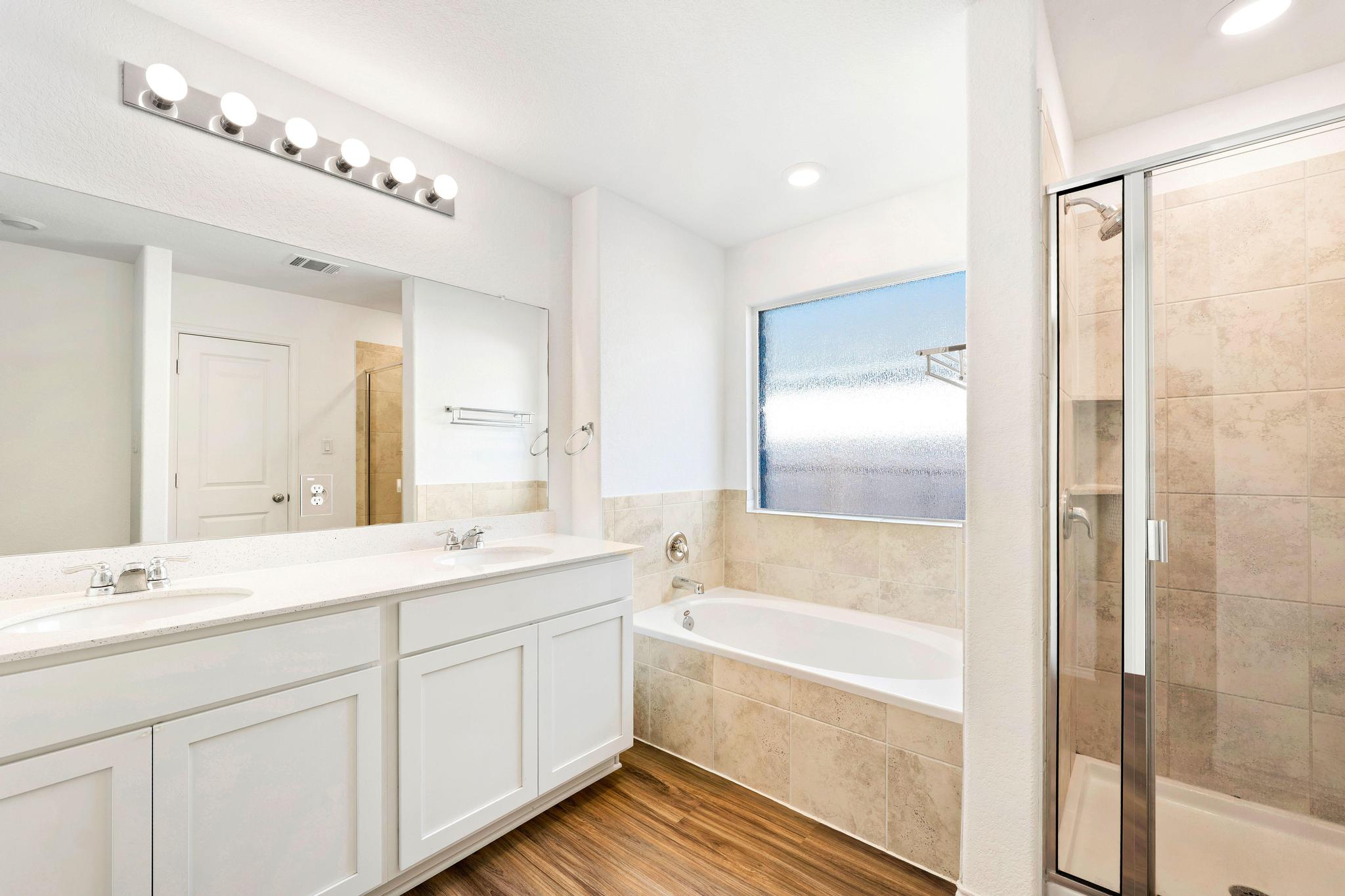 133 Konik Road Georgetown, TX 78626 - Photo 12 of 29 a bathroom with a bathtub a double vanity sink and mirror