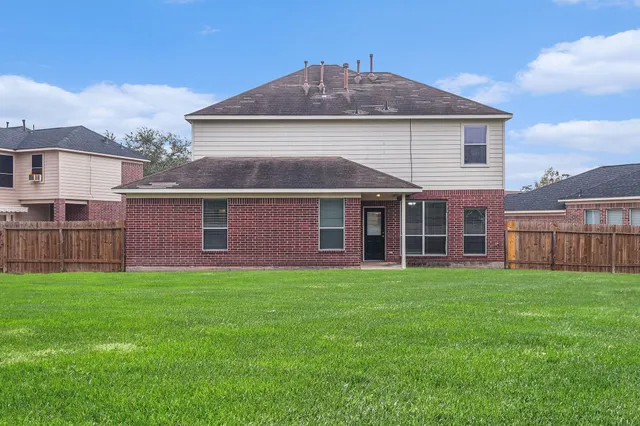 a view of a yard in front of a house with large trees