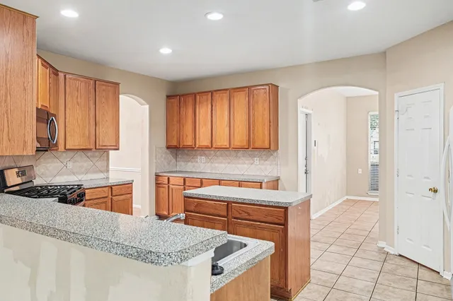 a kitchen with stainless steel appliances granite countertop a stove a sink and a refrigerator