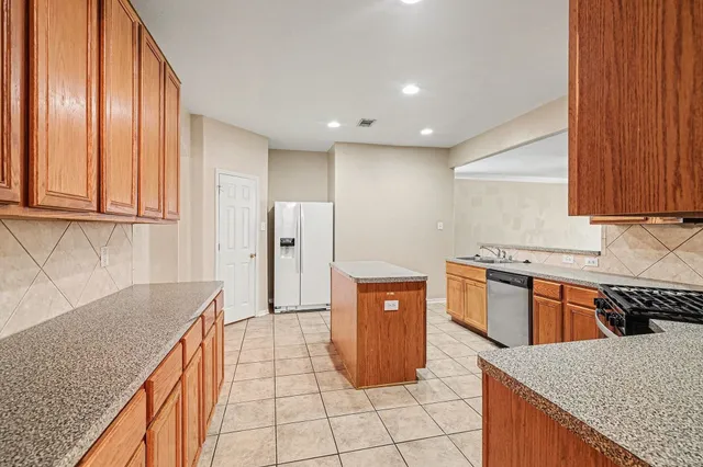 a kitchen with stainless steel appliances granite countertop a refrigerator a sink and dishwasher