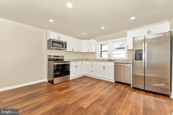 a kitchen with stainless steel appliances a refrigerator and a stove top oven