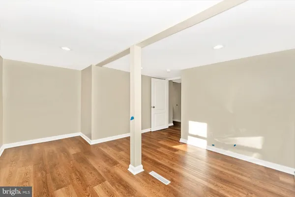 a view of a big room with wooden floor and windows