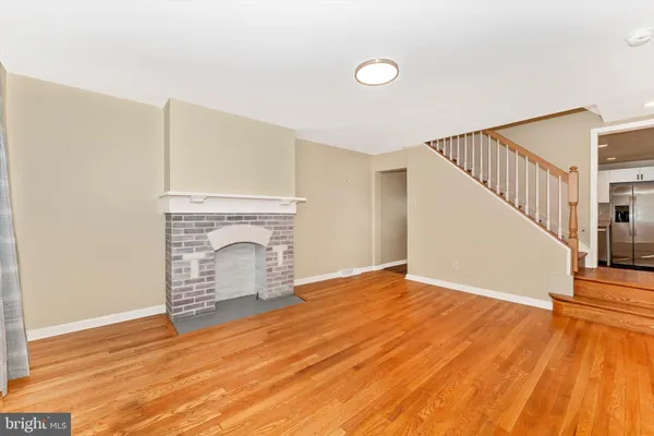 a view of empty room with wooden floor and fireplace