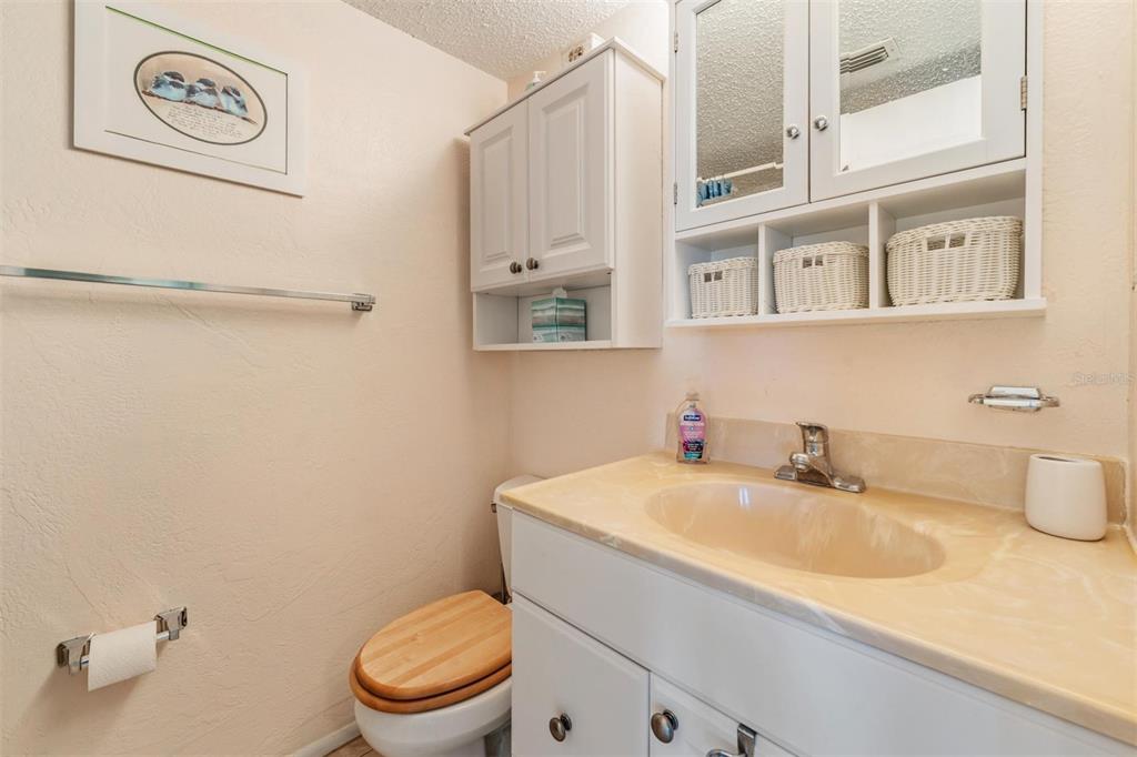2110 Gulf Boulevard, Unit 8 Indian Rocks Beach, FL 33785 - Photo 18 of 34 a bathroom with a sink a toilet and a mirror