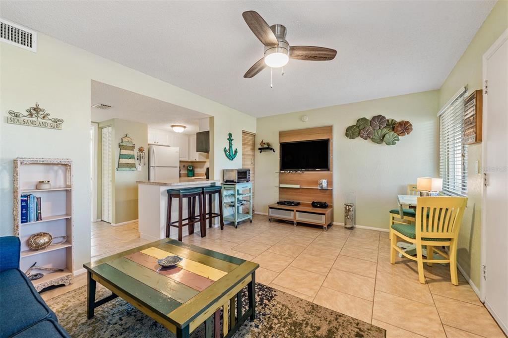 2110 Gulf Boulevard, Unit 8 Indian Rocks Beach, FL 33785 - Photo 7 of 34 a living room with furniture and a flat screen tv