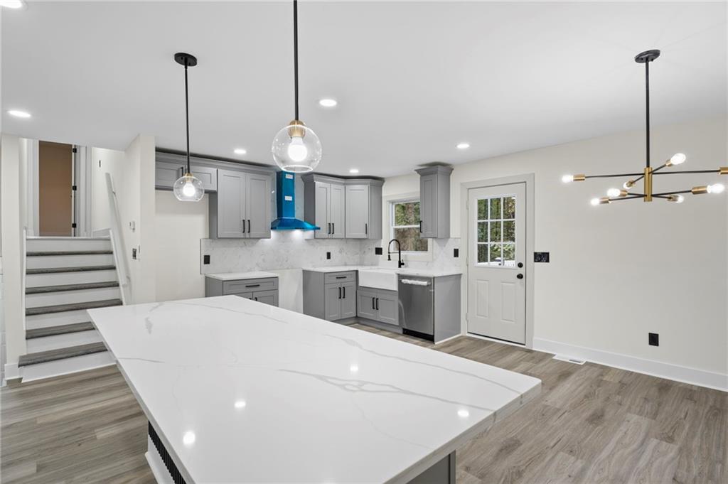 3991 Lindsey Drive Decatur, GA 30035 - Photo 12 of 29 a large white kitchen with a stove a sink dishwasher a kitchen island with wooden floor and cabinets