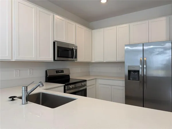a kitchen with a refrigerator sink and cabinets
