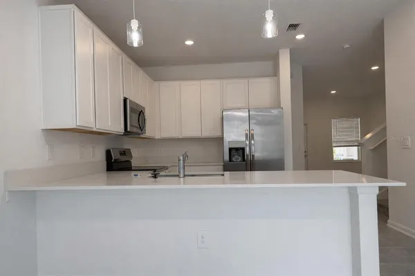 a kitchen with stainless steel appliances granite countertop a sink a stove and a refrigerator