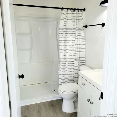 a bathroom with a toilet and a shower curtain