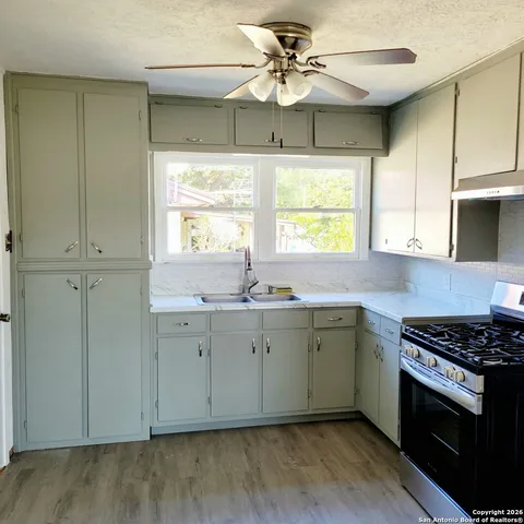 a kitchen with granite countertop a sink stainless steel appliances and window