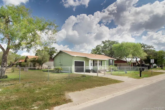a view of a house next to a yard with a fountain
