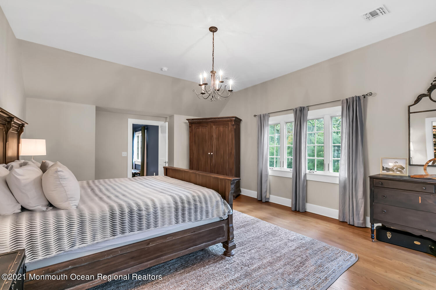 162 Black Point Road Rumson, NJ 07760 - Photo 27 of 58 a bedroom with a large bed a chandelier and windows