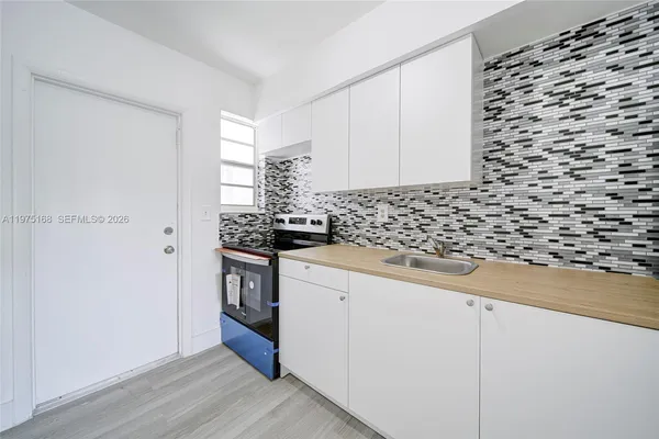 a kitchen with a sink a stove and cabinets