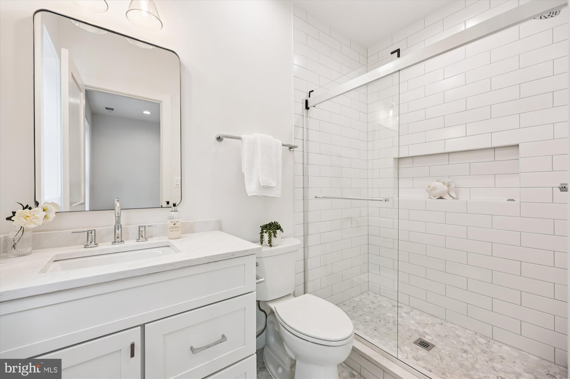 5605 Glenwood Road Bethesda, MD 20817 - Photo 36 of 57 a bathroom with a shower sink vanity mirror and toilet
