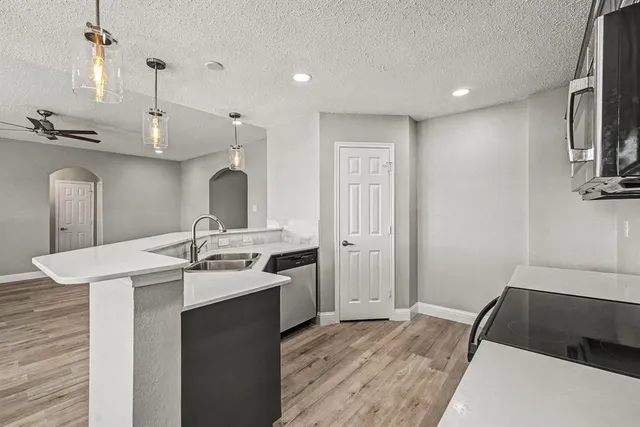 a kitchen with kitchen island a sink stainless steel appliances and cabinets